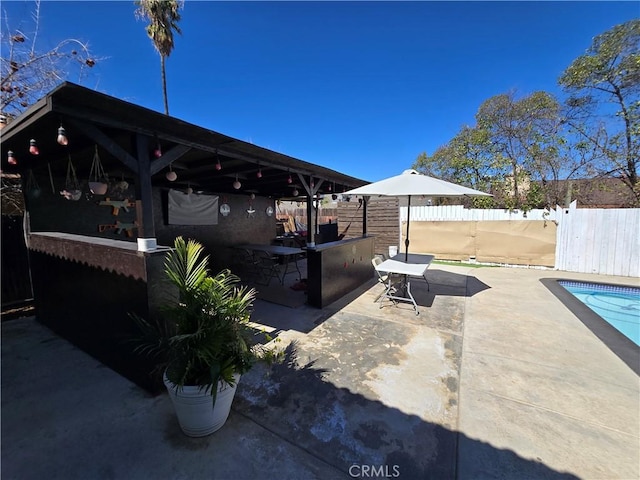 view of patio with fence, outdoor dry bar, and a fenced in pool