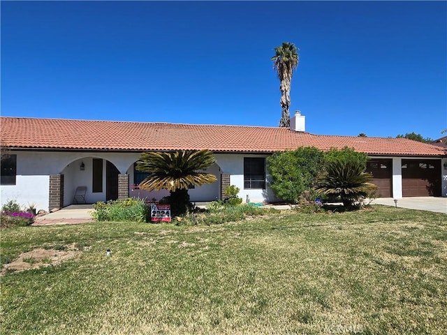 view of front of home featuring a garage, a front lawn, a tile roof, and stucco siding