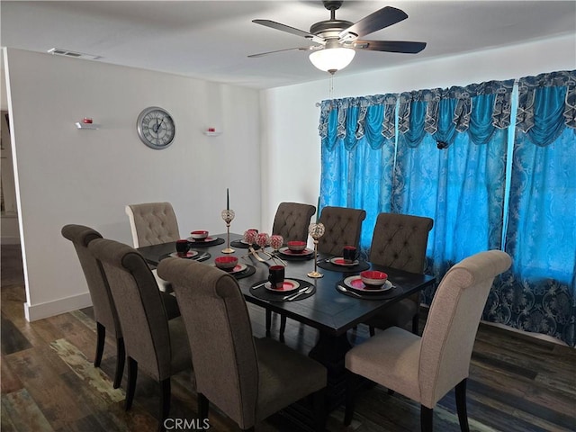 dining space with dark wood-style flooring, visible vents, ceiling fan, and baseboards