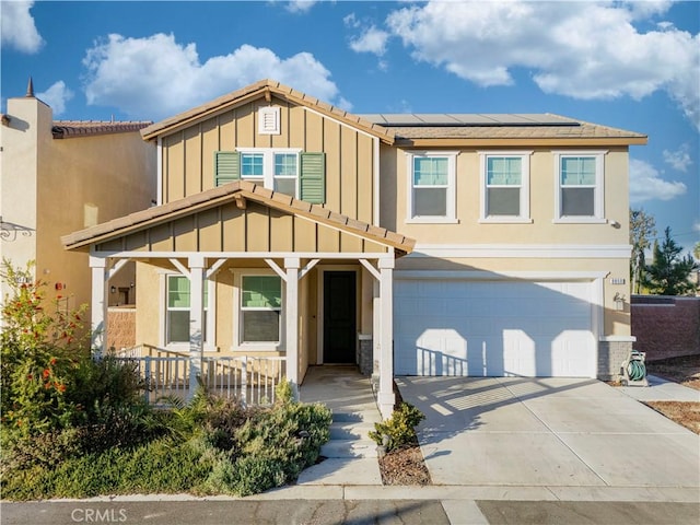 view of front of property with stucco siding, solar panels, board and batten siding, a garage, and driveway