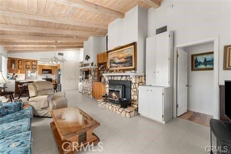 living room featuring vaulted ceiling with beams, a fireplace, and wood ceiling