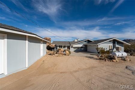 view of property exterior with an attached garage and dirt driveway