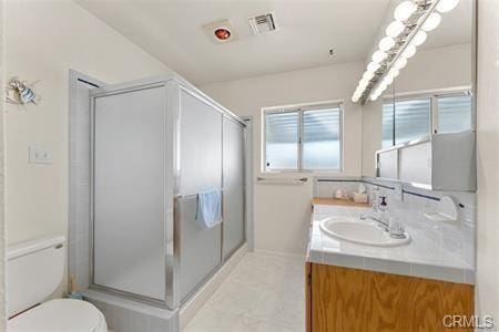 bathroom featuring toilet, visible vents, a stall shower, and vanity