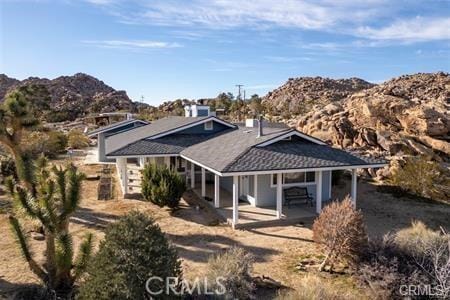 view of front of house with a patio and a mountain view