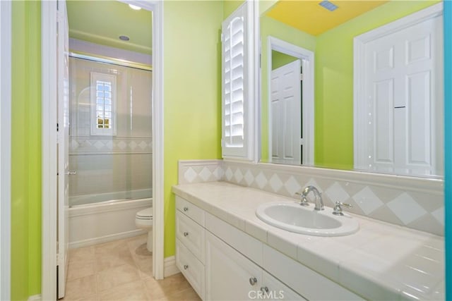 full bathroom with toilet, tile patterned floors, enclosed tub / shower combo, and vanity