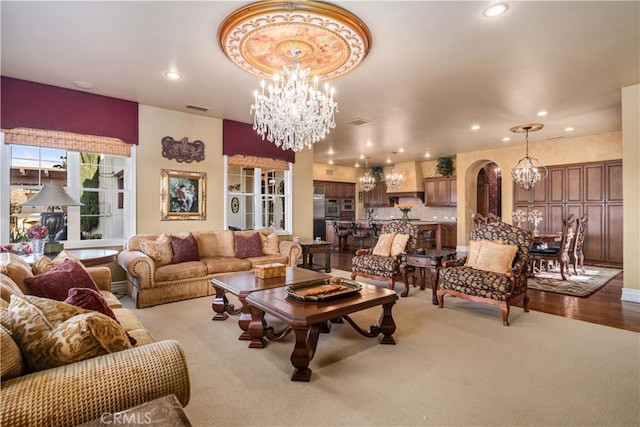 living area with a chandelier, arched walkways, visible vents, and recessed lighting