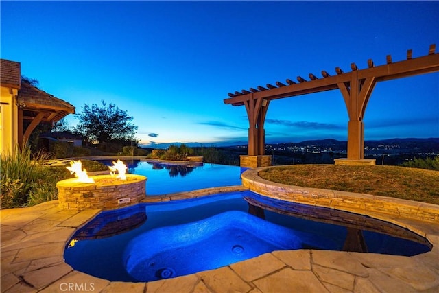 pool at dusk featuring a fire pit and a patio