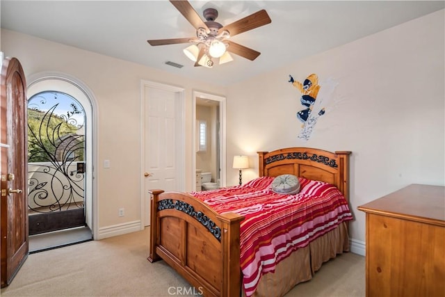 bedroom with light colored carpet, visible vents, a ceiling fan, ensuite bath, and baseboards