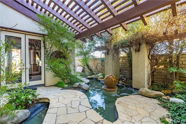 view of patio / terrace with french doors, fence, and a pergola