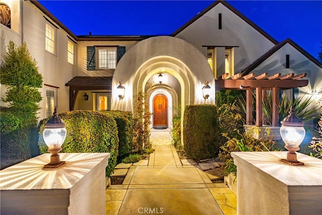 exterior entry at twilight with stucco siding