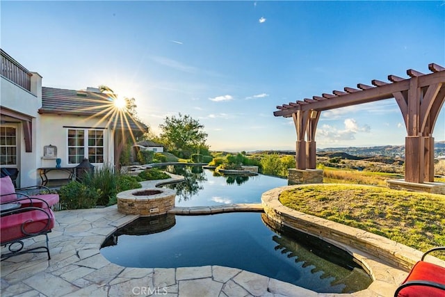 view of swimming pool with a water view, a patio area, and a fire pit