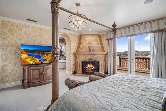 bedroom featuring carpet, arched walkways, wallpapered walls, access to outside, and a tile fireplace