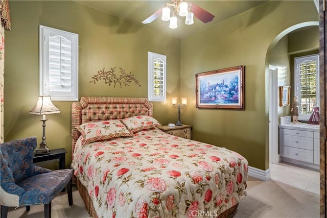 bedroom featuring arched walkways, light carpet, ceiling fan, and baseboards