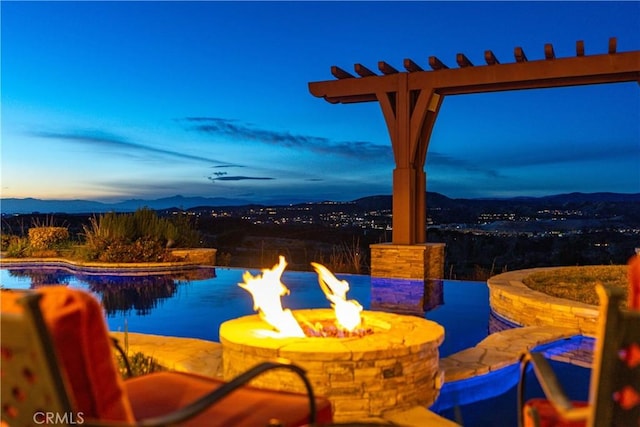 view of pool featuring an outdoor fire pit, a mountain view, and a patio