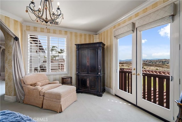 sitting room with ornamental molding, a notable chandelier, carpet floors, and wallpapered walls