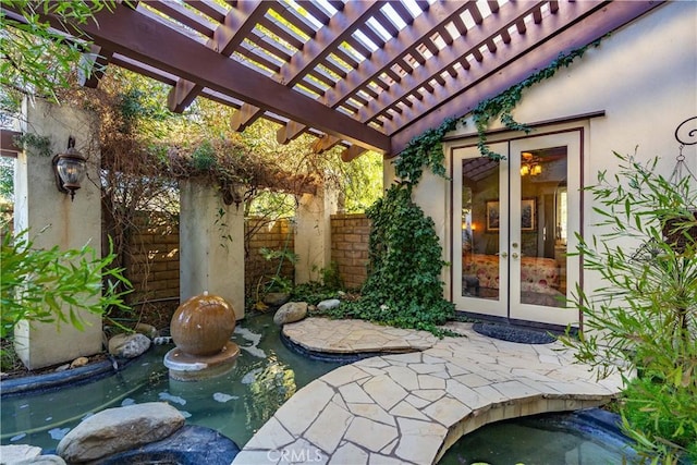 view of patio / terrace with french doors, fence, and a pergola