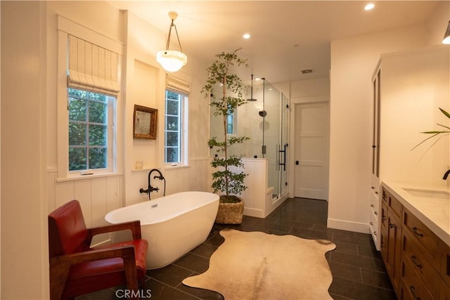 bathroom with tile patterned flooring, recessed lighting, vanity, a soaking tub, and a stall shower