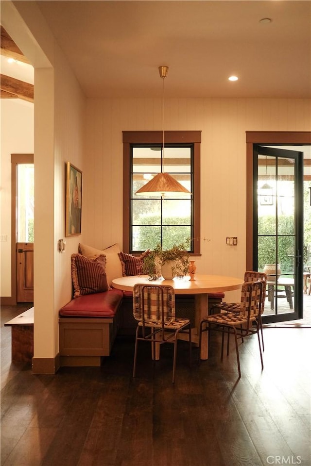 dining space with breakfast area, dark wood-type flooring, and baseboards