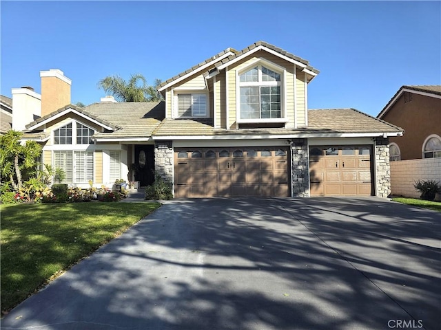 view of front of house with driveway, stone siding, a front lawn, and a tiled roof