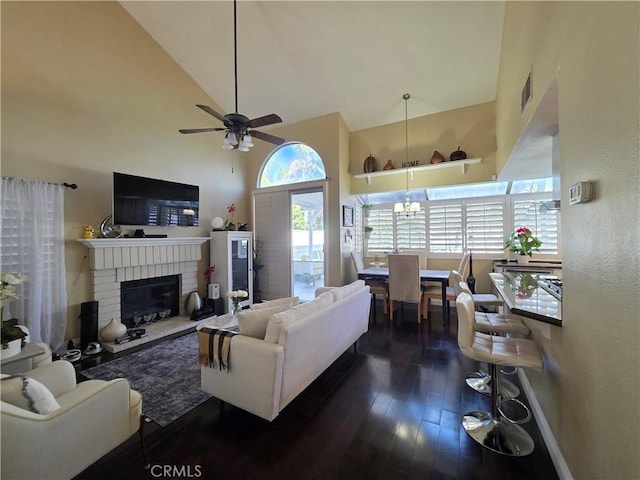 living room with baseboards, visible vents, dark wood-style floors, a brick fireplace, and high vaulted ceiling