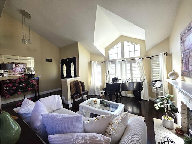 living area with high vaulted ceiling, visible vents, baseboards, and wood finished floors