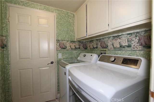 washroom featuring washing machine and dryer and cabinet space