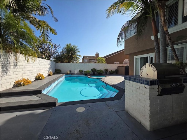 view of pool featuring a patio area, a fenced backyard, and a pool with connected hot tub