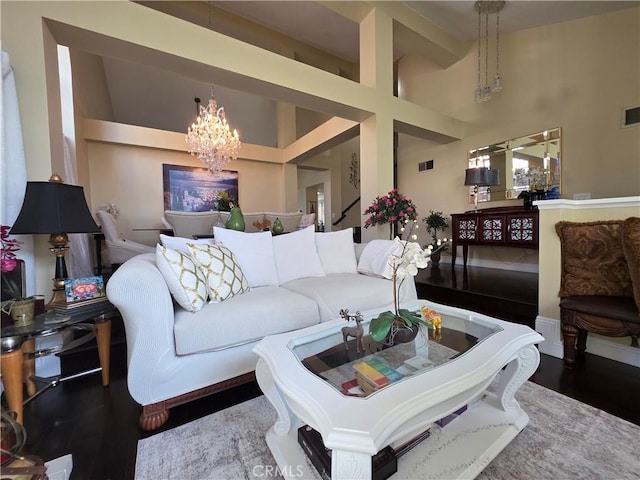 living area featuring high vaulted ceiling, wood finished floors, visible vents, and an inviting chandelier