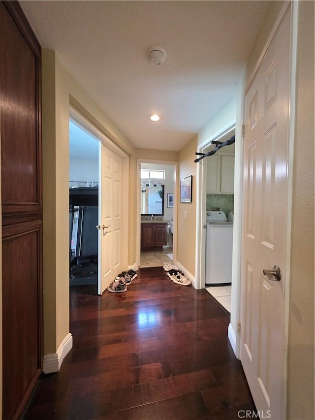 corridor featuring washer and dryer, dark wood-style flooring, baseboards, and recessed lighting