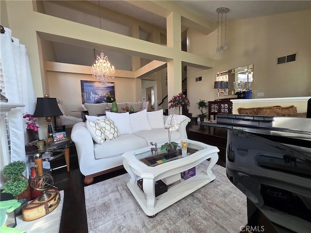 living area with high vaulted ceiling, visible vents, and an inviting chandelier