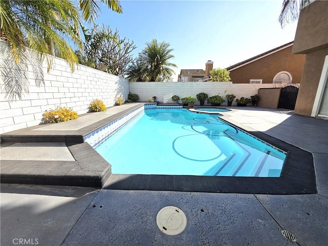 view of pool with a patio, a fenced backyard, and a pool with connected hot tub