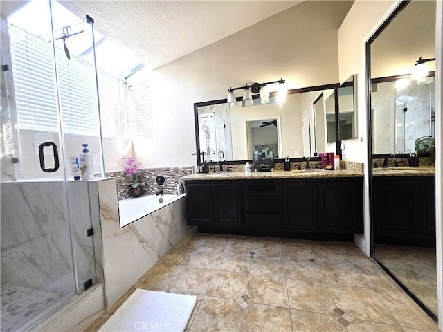 full bathroom featuring a garden tub, a sink, a marble finish shower, and double vanity