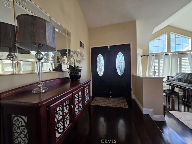 foyer entrance featuring baseboards, visible vents, vaulted ceiling, and dark wood-style flooring