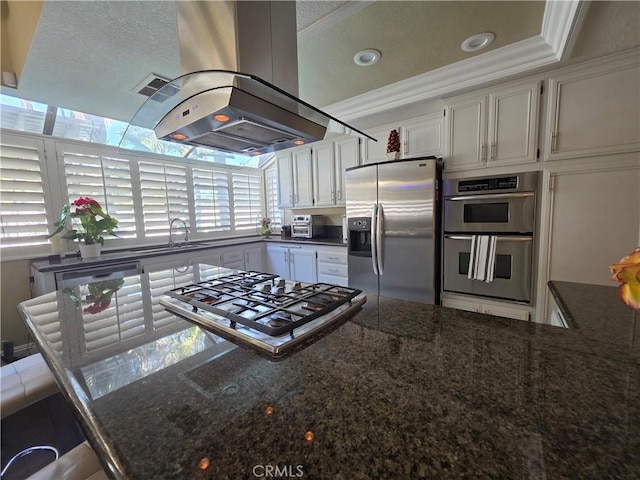 kitchen featuring a sink, white cabinets, ornamental molding, appliances with stainless steel finishes, and island exhaust hood