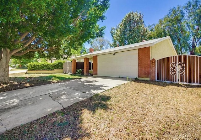 ranch-style house featuring an attached garage, driveway, a gate, and brick siding