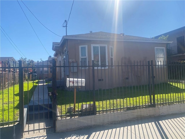 view of front of property featuring a front lawn, a fenced front yard, and a gate