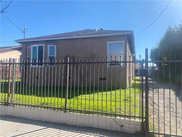 view of gate with fence and a yard