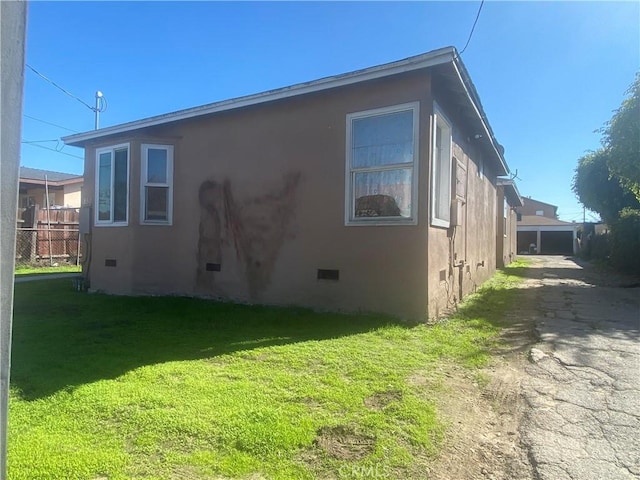 view of property exterior with a yard, crawl space, and stucco siding