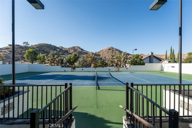 view of sport court with fence and a mountain view