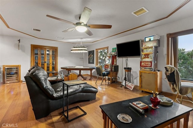 living room with a ceiling fan, wine cooler, visible vents, and light wood finished floors