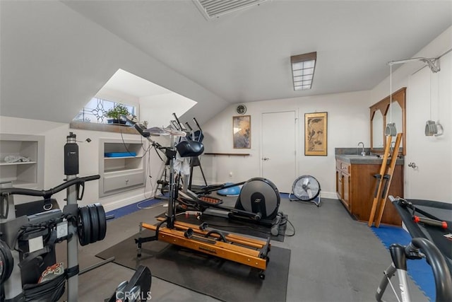 workout room featuring lofted ceiling, built in shelves, a sink, visible vents, and baseboards