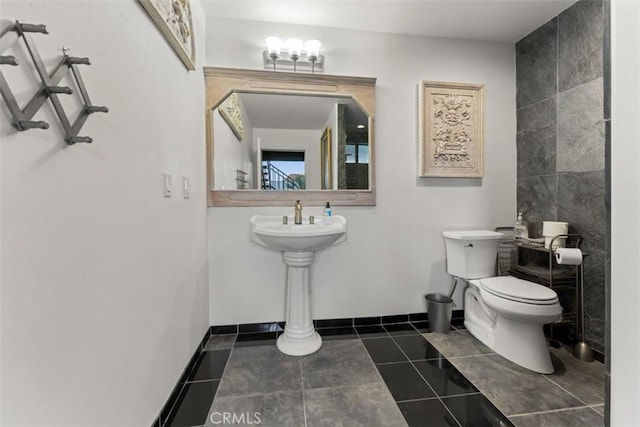 bathroom with tile patterned flooring, toilet, and baseboards