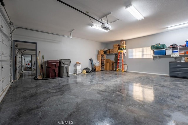 garage with baseboards and a garage door opener