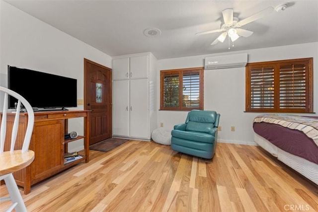 bedroom featuring a ceiling fan, a closet, light wood-style flooring, and a wall mounted AC