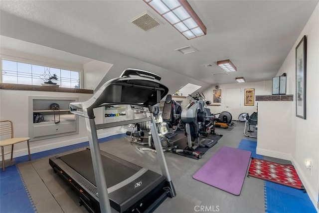 workout area with lofted ceiling, visible vents, and baseboards