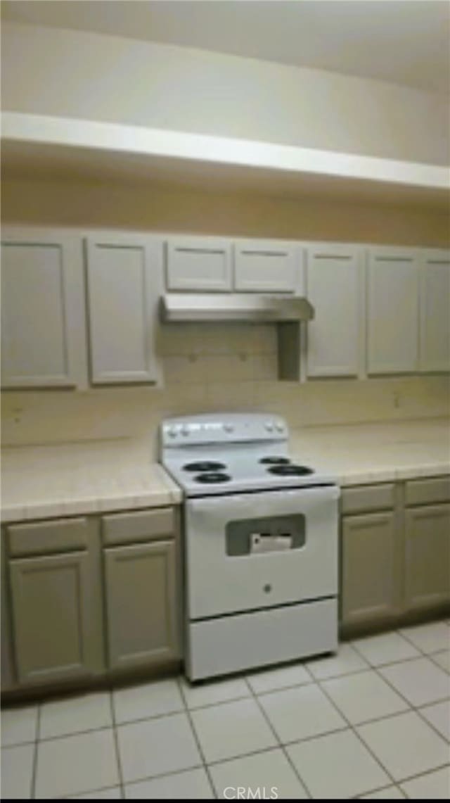 kitchen with light countertops, white range with electric cooktop, and under cabinet range hood