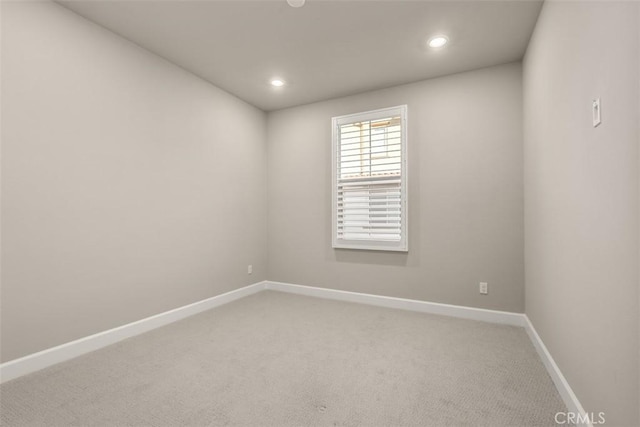 carpeted empty room featuring recessed lighting and baseboards