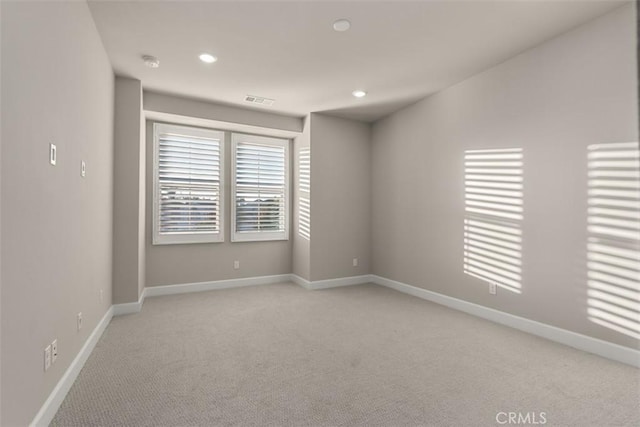 spare room featuring baseboards, recessed lighting, visible vents, and light colored carpet