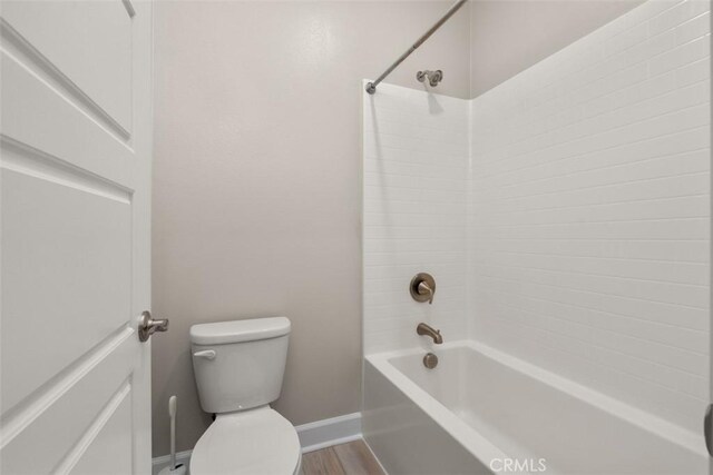 full bathroom featuring bathtub / shower combination, toilet, and baseboards