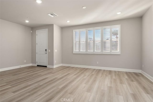 unfurnished room featuring baseboards, light wood finished floors, visible vents, and recessed lighting